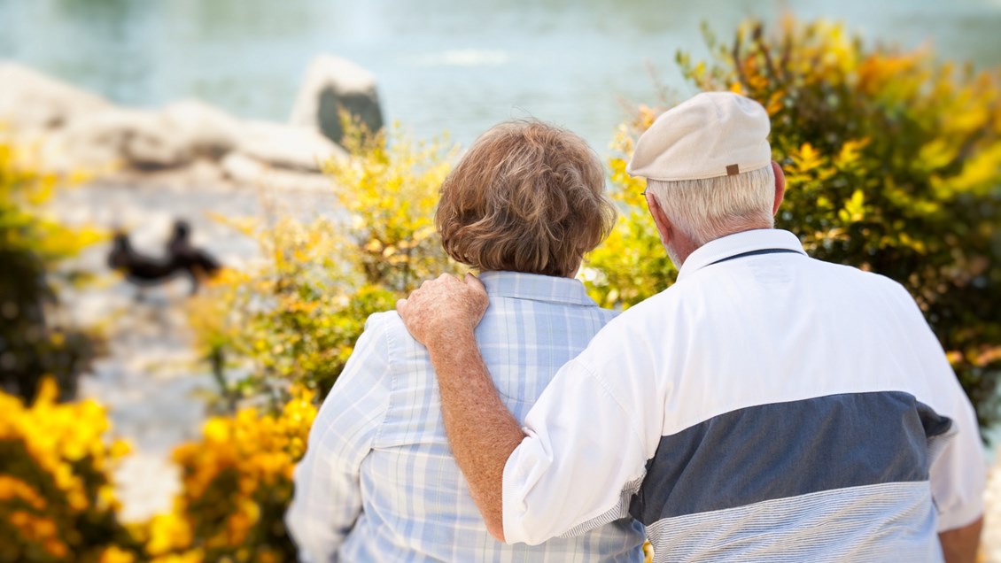 En eldre mann og kvinne står intill hverandre og ser utover sjøen