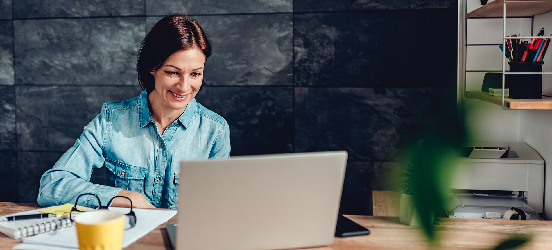 Kvinne sitter på hjemmekontor og deltar på webinar