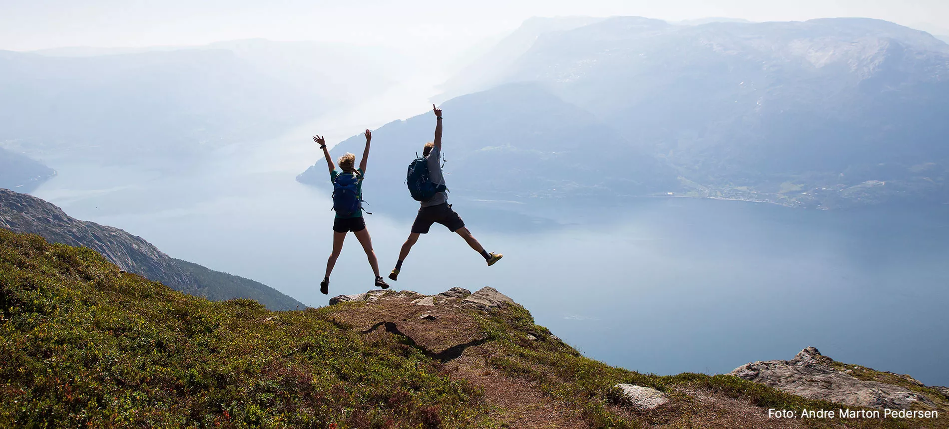 To personer på fjelltopp som hopper