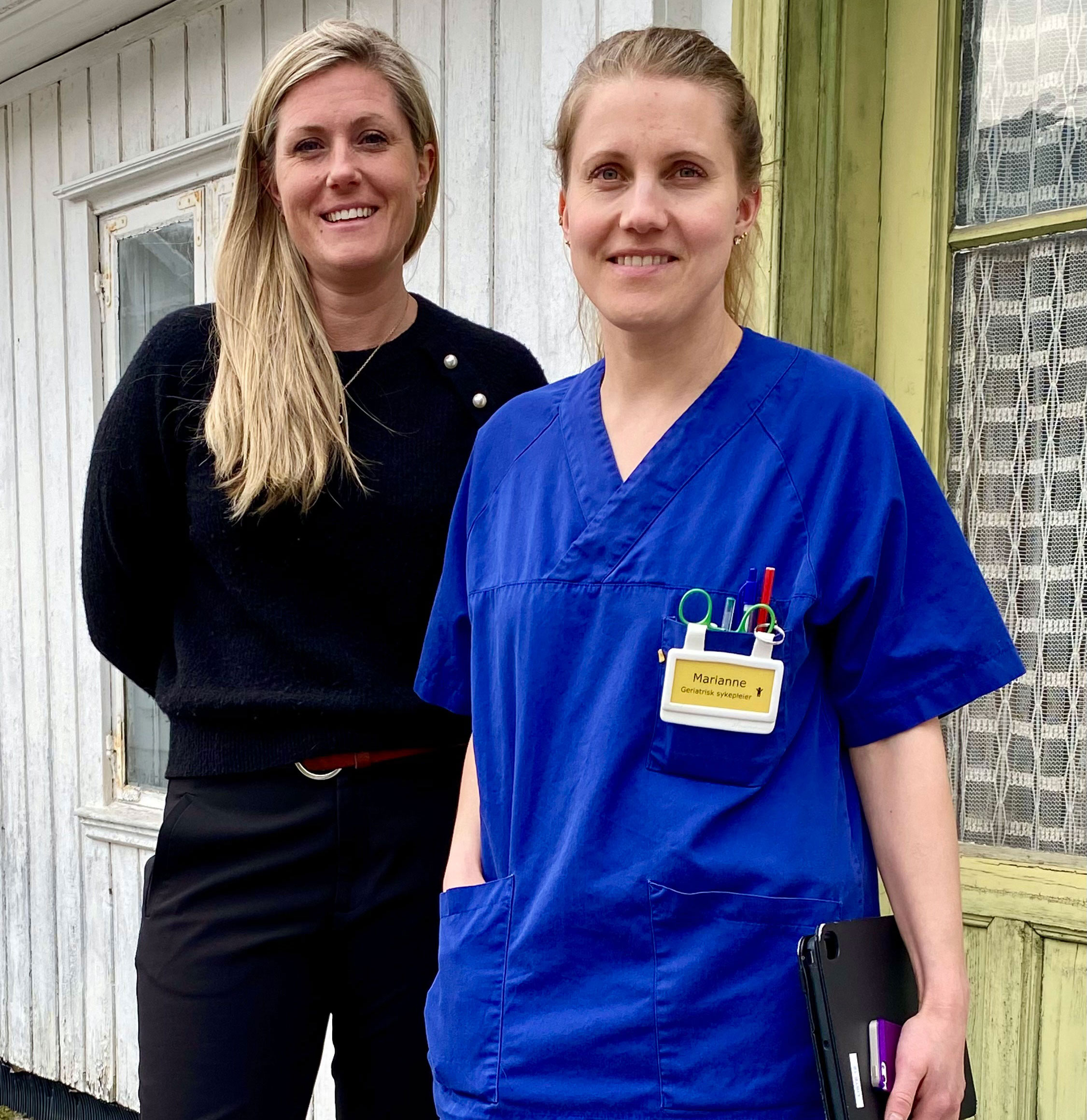 To damer står foran hus