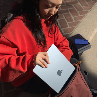 En student legger MacBook Air i ryggsekken sin