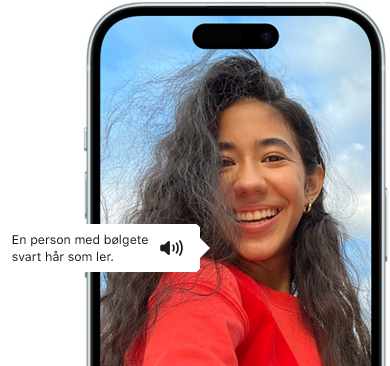 iPhone 15 viser VoiceOver-funksjonen som forteller hva bildet viser, en person med bølgete svart hår, som ler