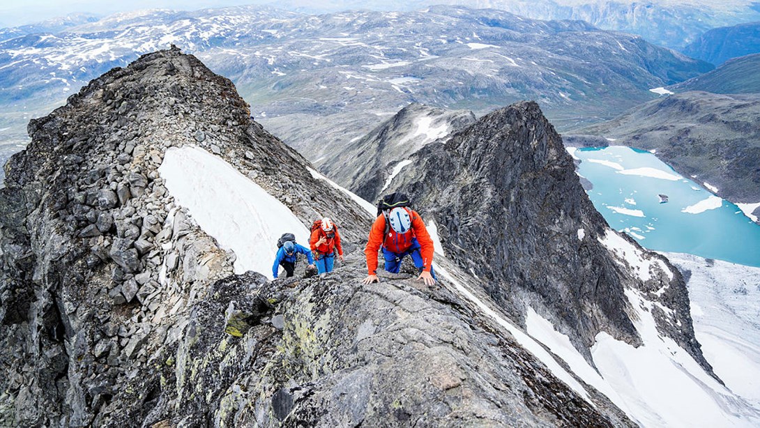 tre personer som klatrer på fjellrygg.foto