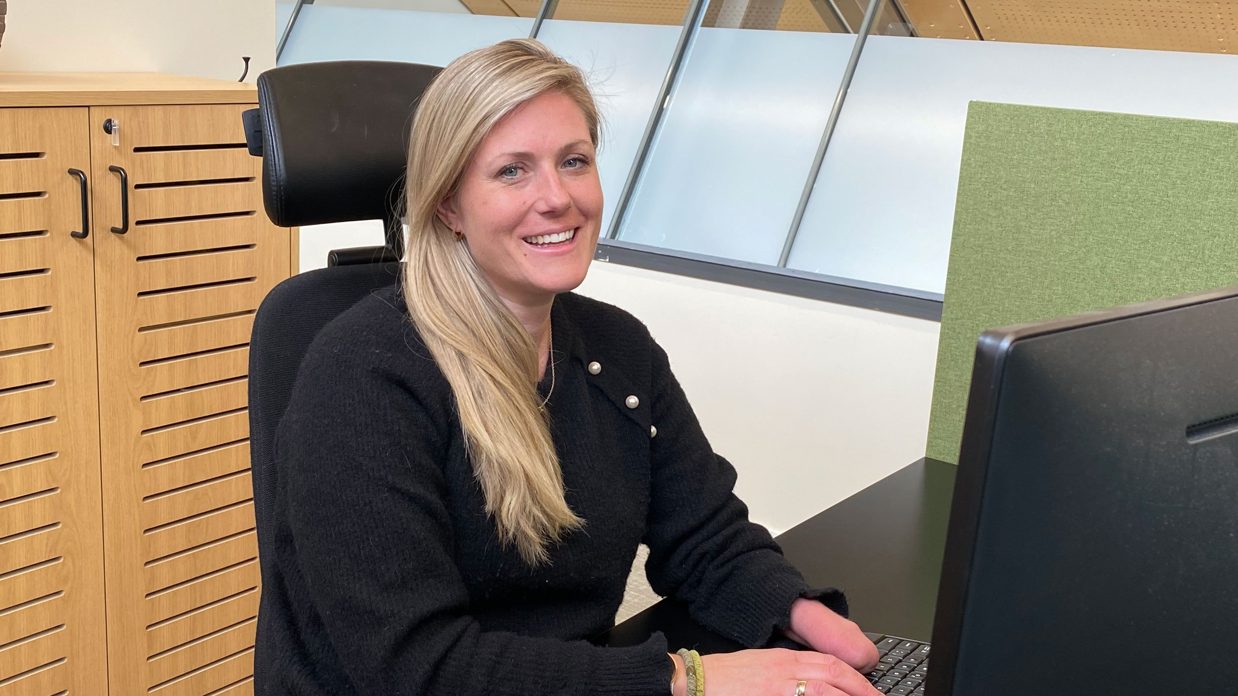 Dame sitter ved kontorpulten